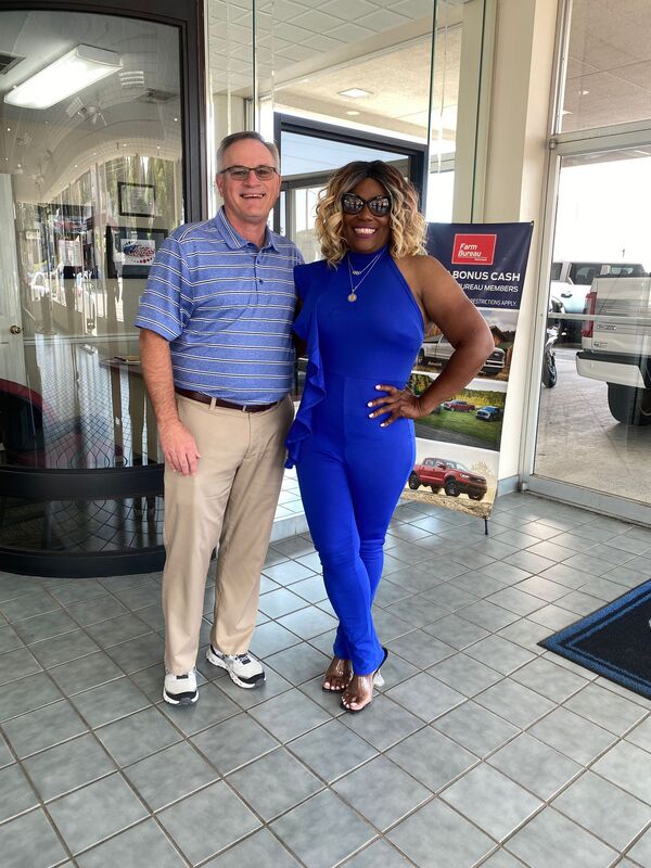 Sharrieffa Barksdale with a sponsor representative beside a Farm Bureau banner