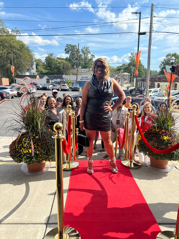 A guest arriving on the red carpet while a crowd looks on