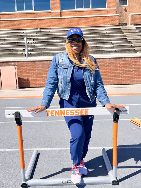 Sharrieffa Barksdale posing beside a Tennessee hurdle on the track